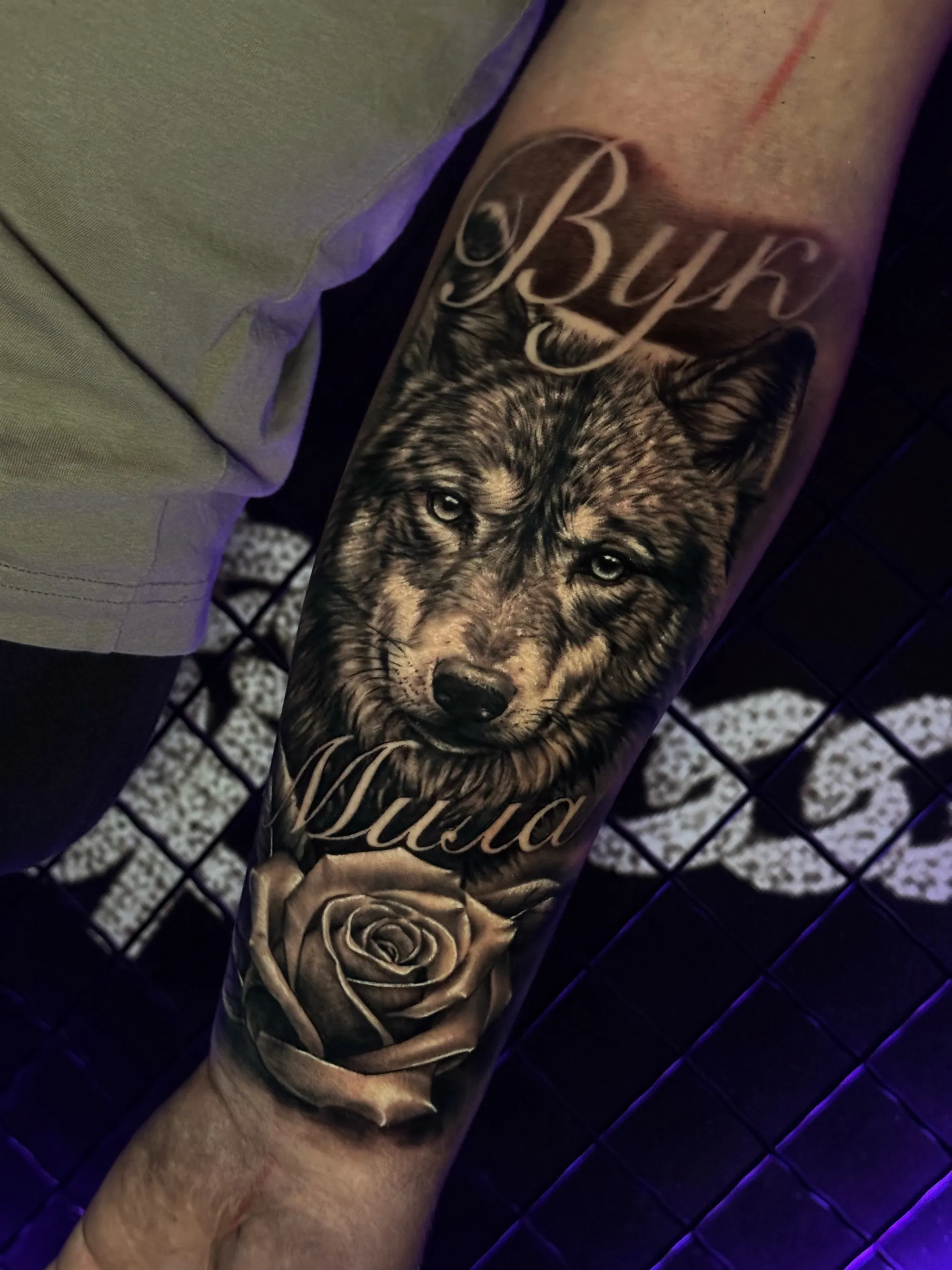 Realistična tetovaža vučje glave sa ćiriličnim natpisima "Vuk" i  "Mila" i ružom na podlaktici, Dropz Tattoo Studio Niš